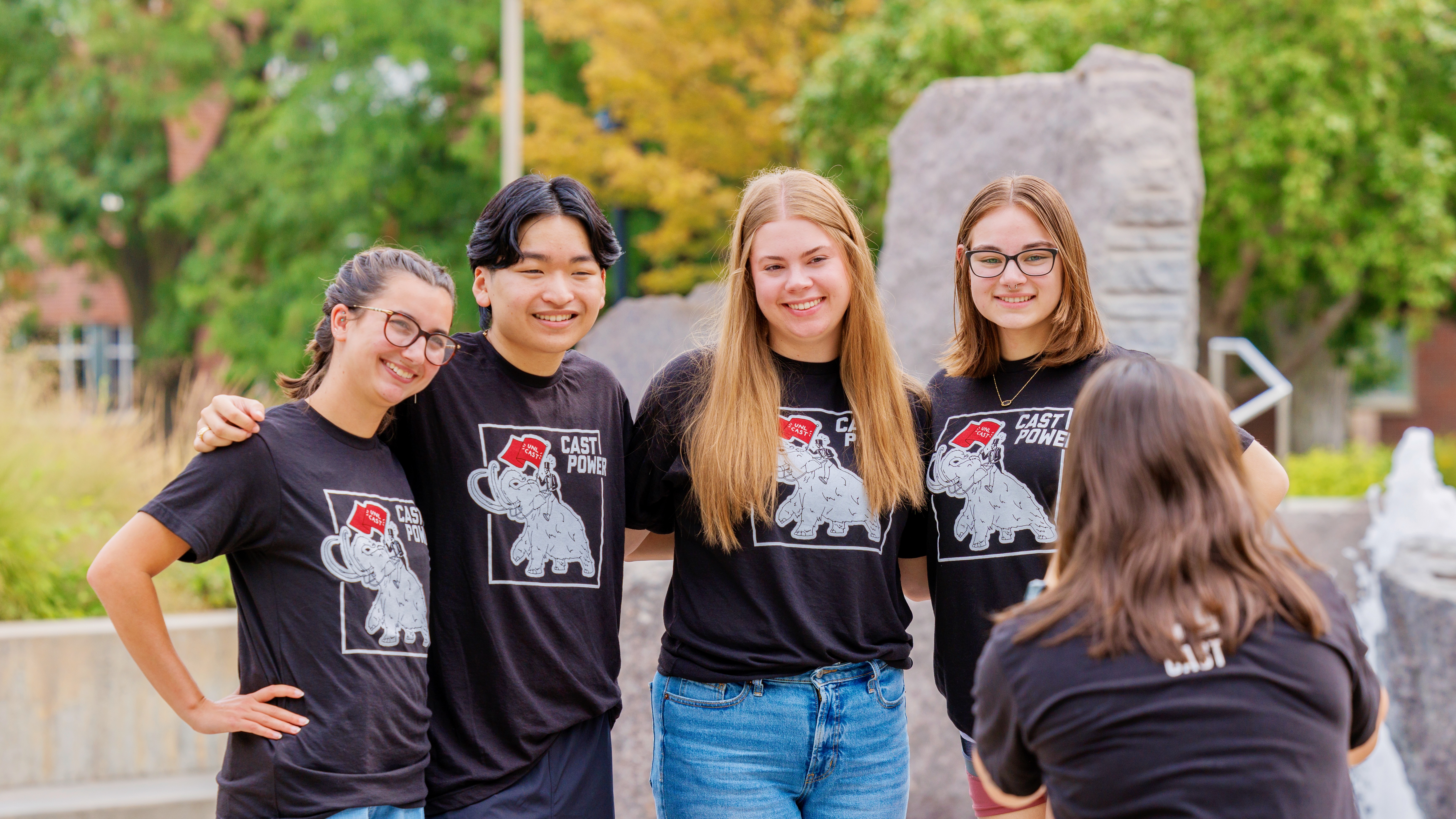 Four mentors posing for a photo by the fountain at Nebraska Union.