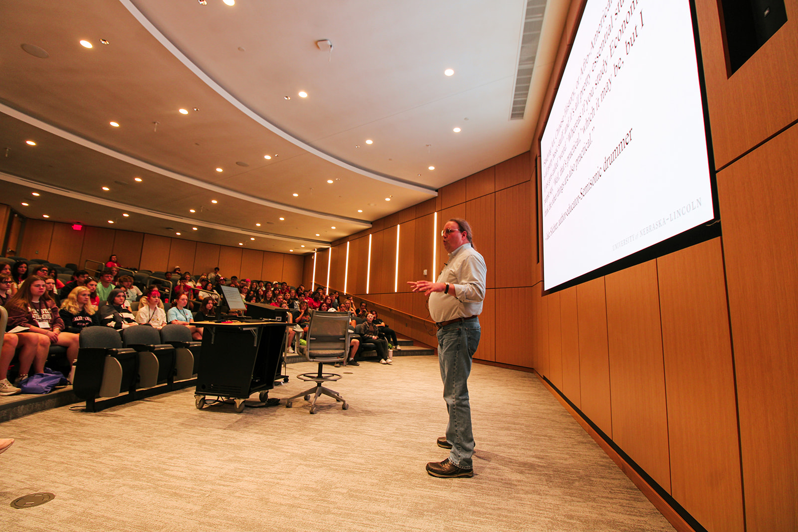 Man giving a presentation in a large auditorium. 