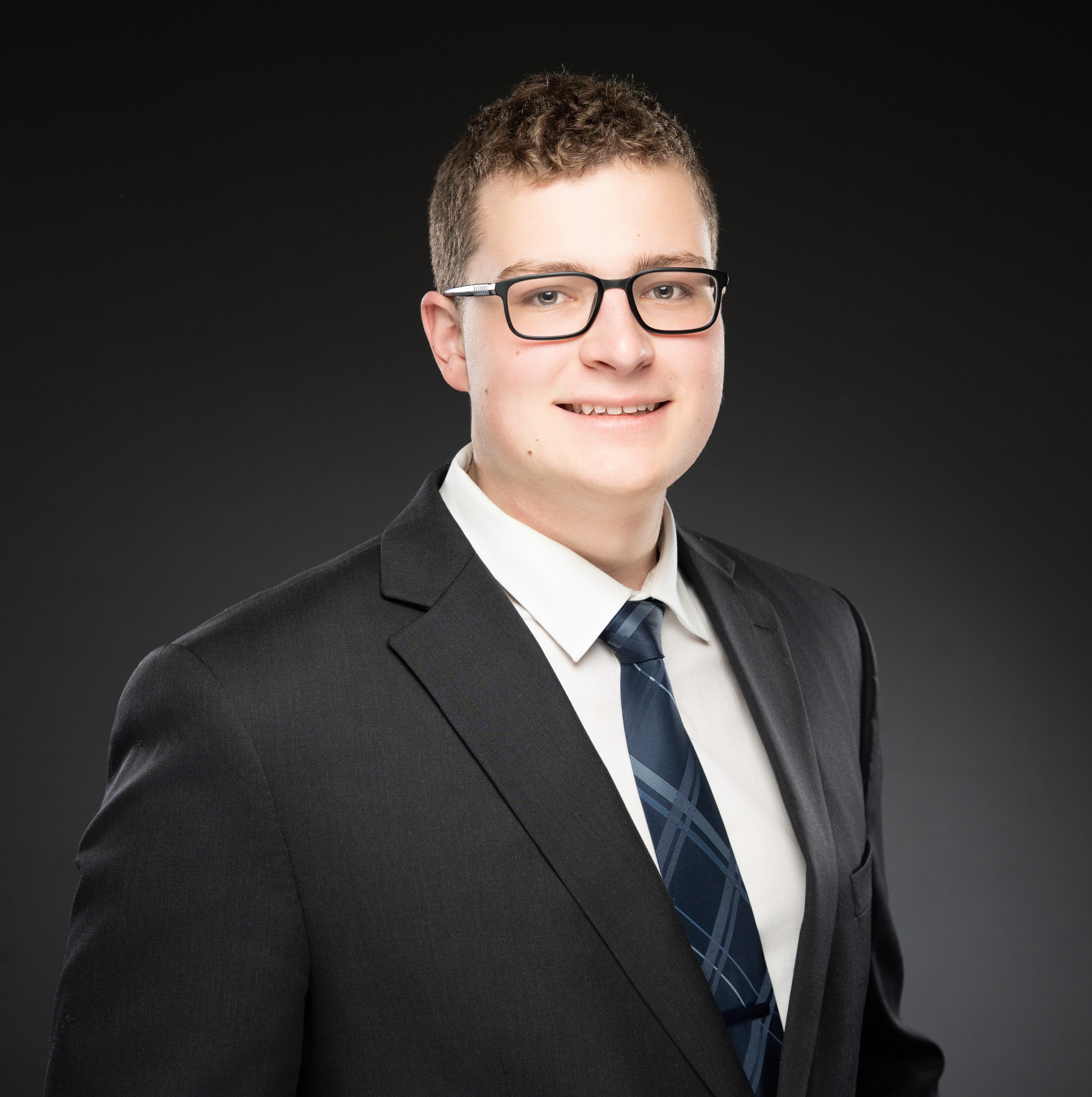 Photo of Dathan smiling in a suit