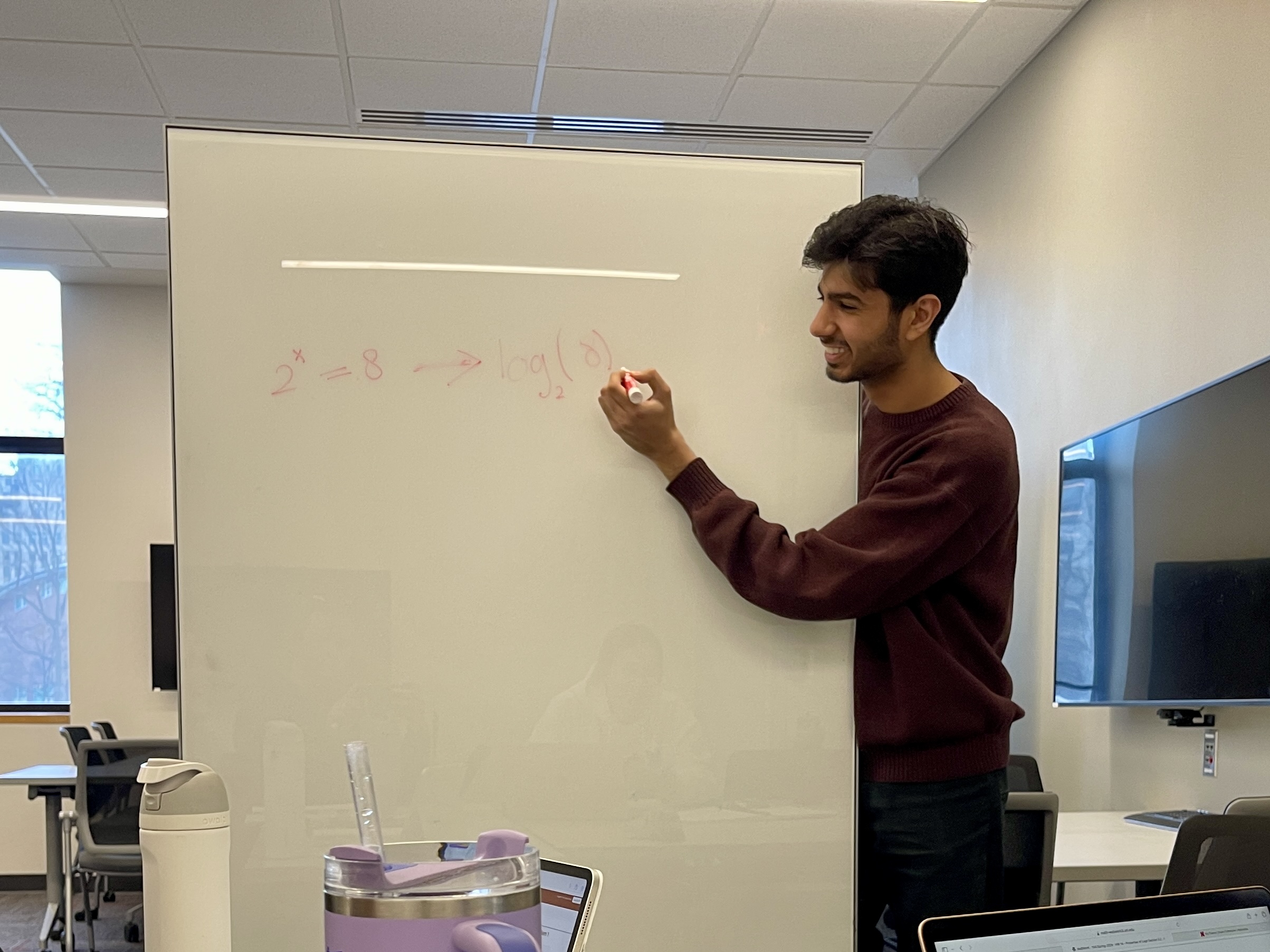 Learning Consultant Yasir writing on a whiteboard.