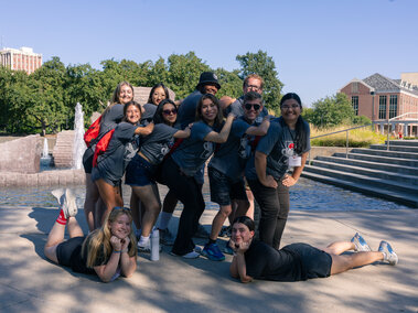 Group of transfer student participants from 2025 4-day event posing in front of fountain.