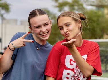 Two students standing together posing.