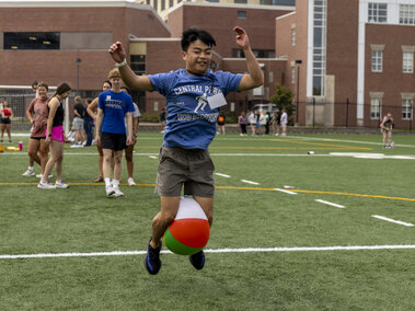 A student competing in a relay race with a beach ball.