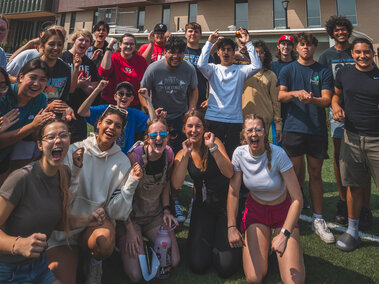 A group of students cheering on a soccer field. 