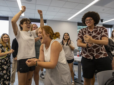 Group of students playing rock, paper, scissors. 